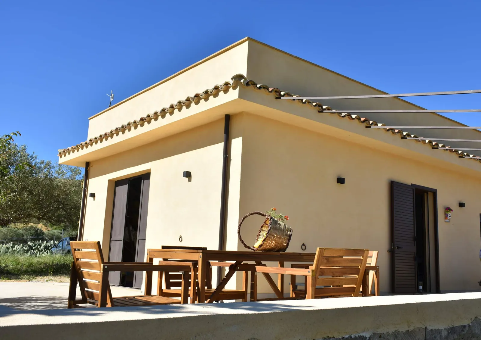 La casa e la terrazza col tavolo di legno